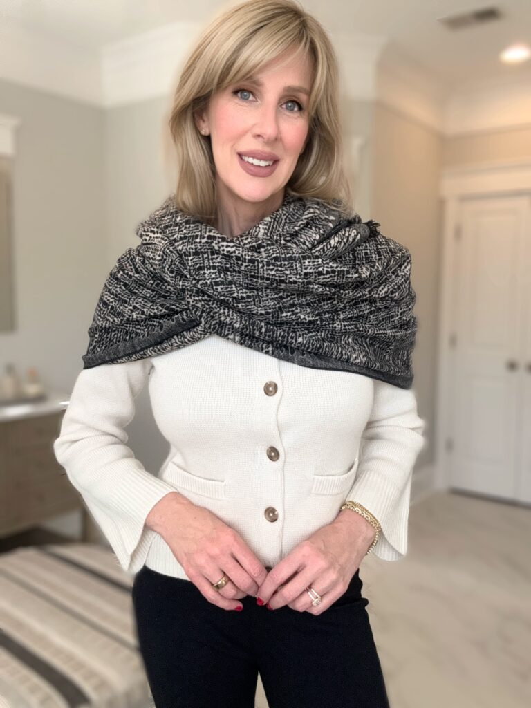 woman wearing a cream sweater and black and cream silk scarf demonstrating classic style for women