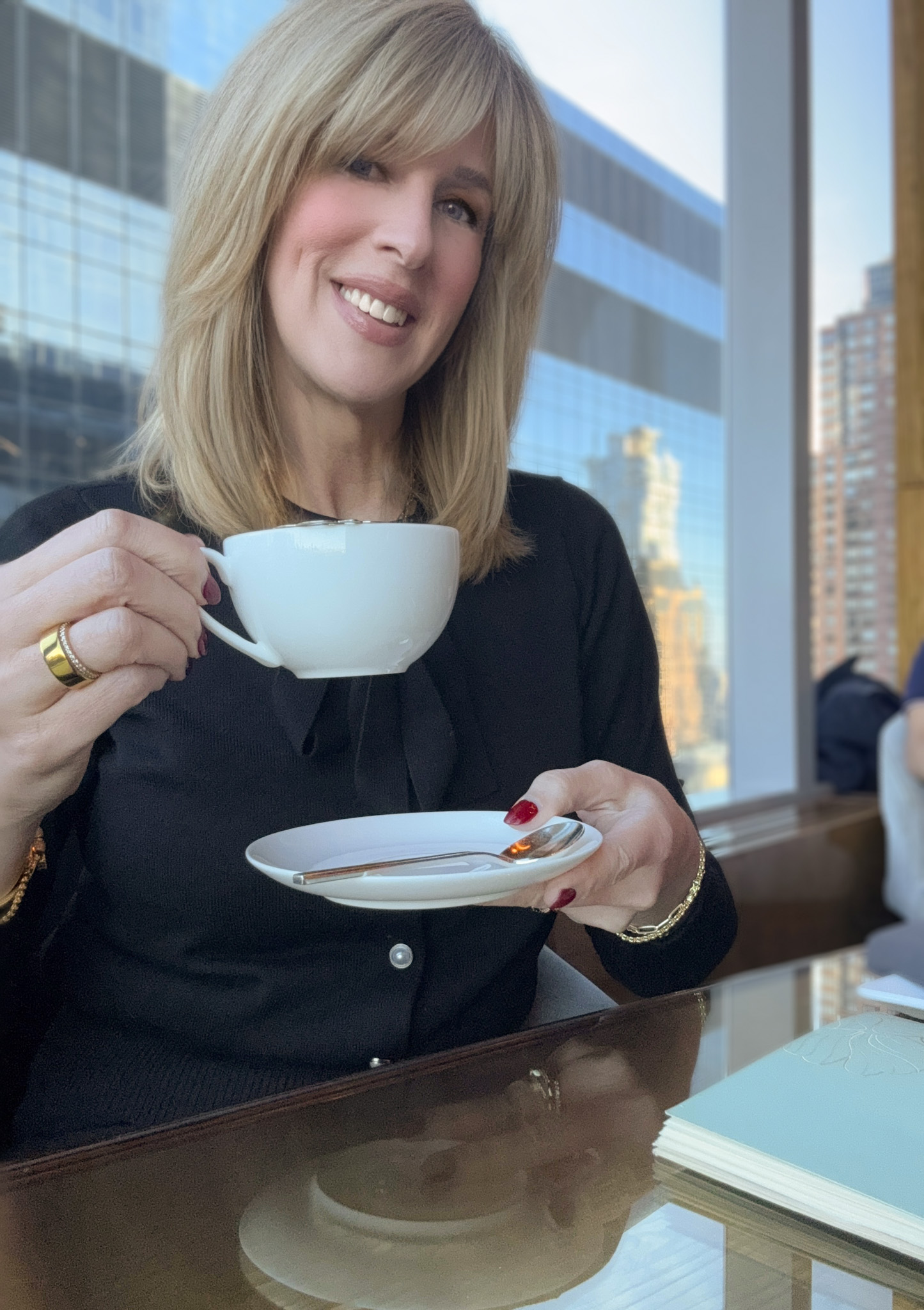 woman having tea at the mandarin oriental nyc overlooking central park sharing nyc travel guide tips